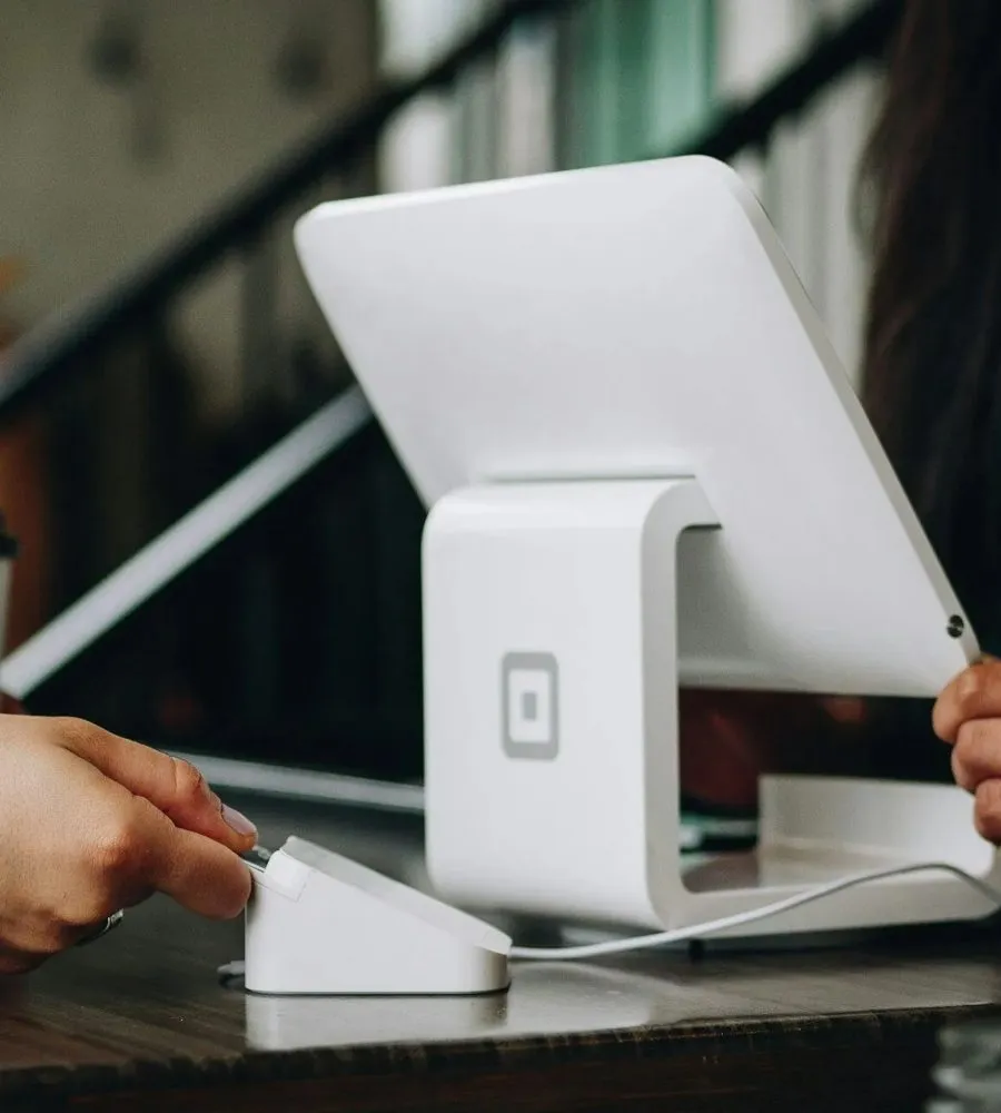 A customer tapping a card on a payment reader at a counter