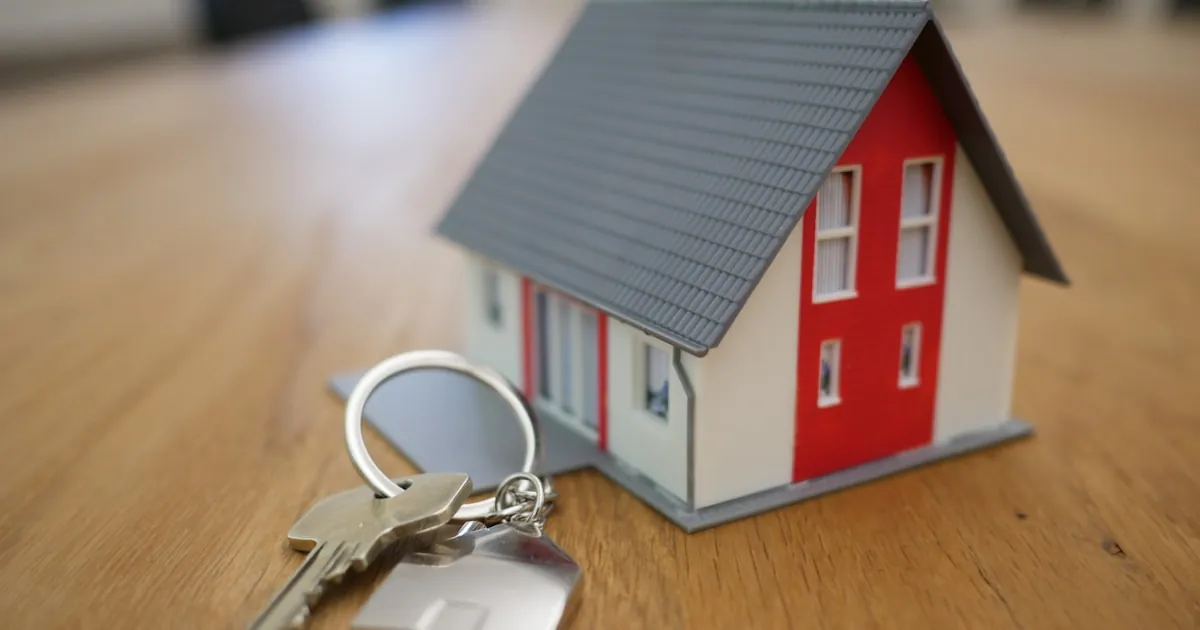 A model house and a set of keys on a desk