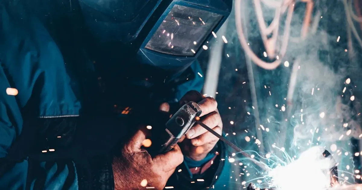 A welder working with sparks flying in a workshop